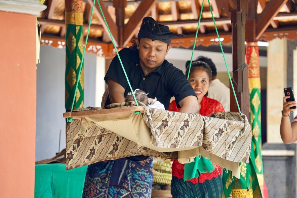 Ehepaar in Bali mit Kind in Wiege