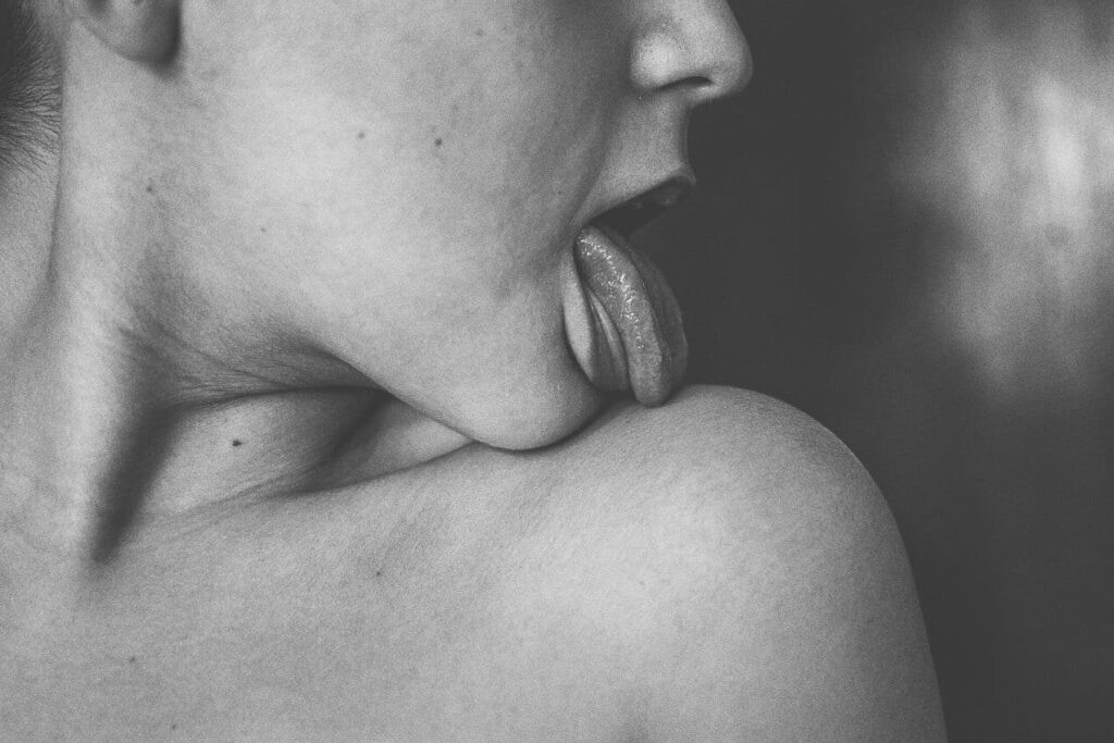 Eine Person leckt die eigene Schulter ab, schwarz-weiss-Bild Schöner Sex ist kein Zufall - mit Tipps von der Expertin macht Sex wieder Spass.