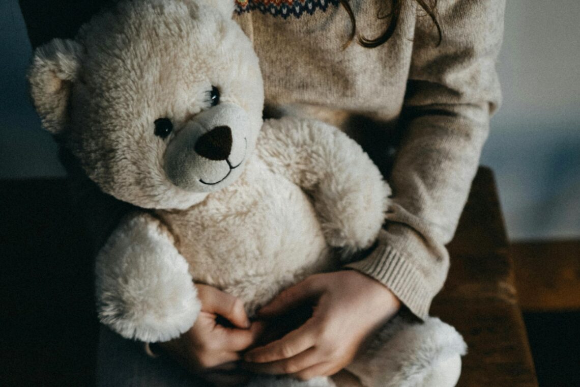 Kind hält Teddybär im Arm - Wie kann man sein Kind vor Gewalt schützen?