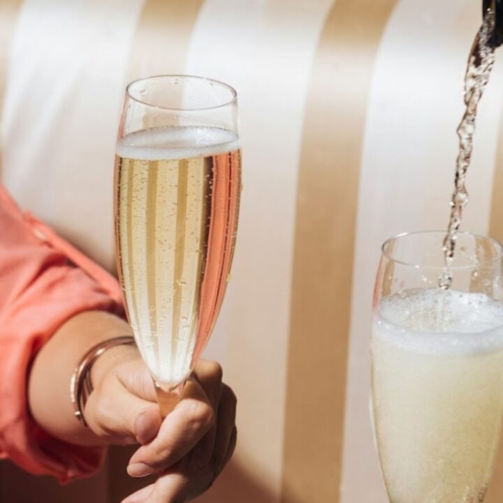 Champagner-Gläser, die gerade frisch gefüllt werden. Alkohol trinken ist ein kontroverses Thema - ist Alkohol Gift oder Genuss?