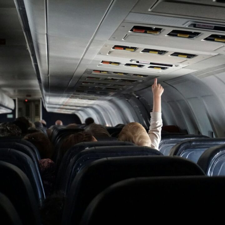 Kind streckt sich im Flugzeug nach der Decke. Wie überlebt man einen Langstreckenflug mit Kleinkind oder Baby? Wir haben erprobte Tipps.