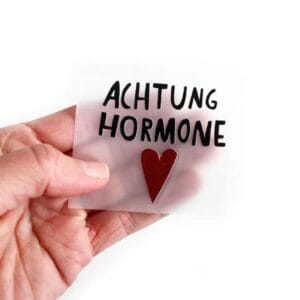 Achtung, Hormone! Das Bügelbild für alle Stimmungslagen – ohne Rand, dafür mit Ansage. Waschbar, haltbar, oho!