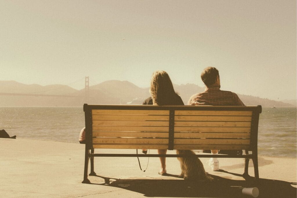 Frau und Mann auf einer Parkbank, mit Blick auf die Golden Gate Bridge - Alltagsstress killt die Beziehung? 6 Strategien für weniger Streit