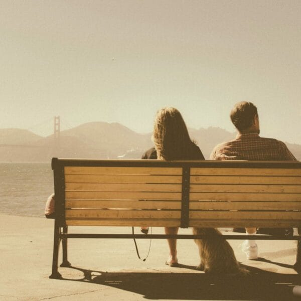 Frau und Mann auf einer Parkbank, mit Blick auf die Golden Gate Bridge - Alltagsstress killt die Beziehung? 6 Strategien für weniger Streit