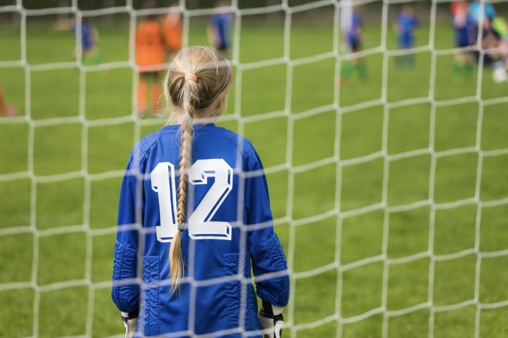 Ein Mädchen steht im Goal bei einem Fussballmatch.