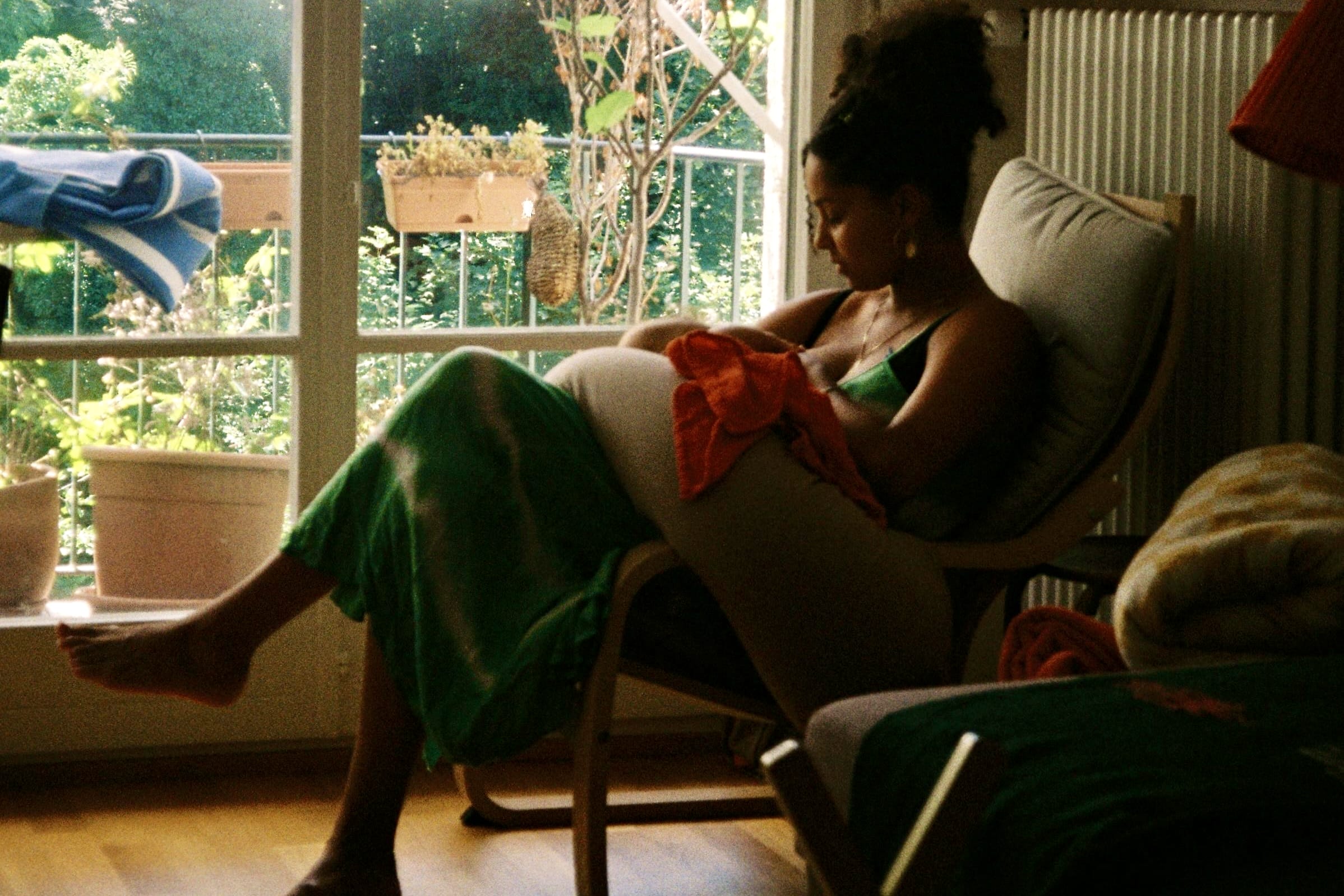 Anja Glover sitzt mit ihrem Baby im Arm auf einem Stuhl.