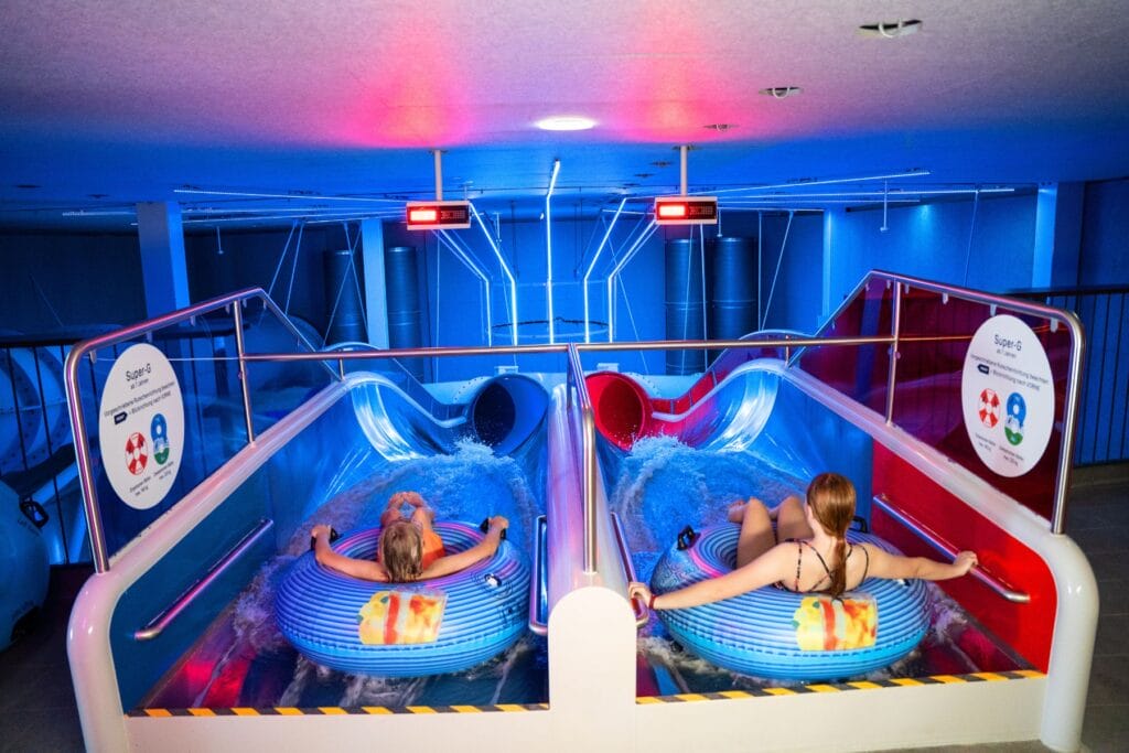 Zwei Mädchen auf Reifen sitzend am Start der Rutschbahn Super-G im Säntispark. - Ostschweiz mit Kindern bei Regen - unsere erprobten Tipps