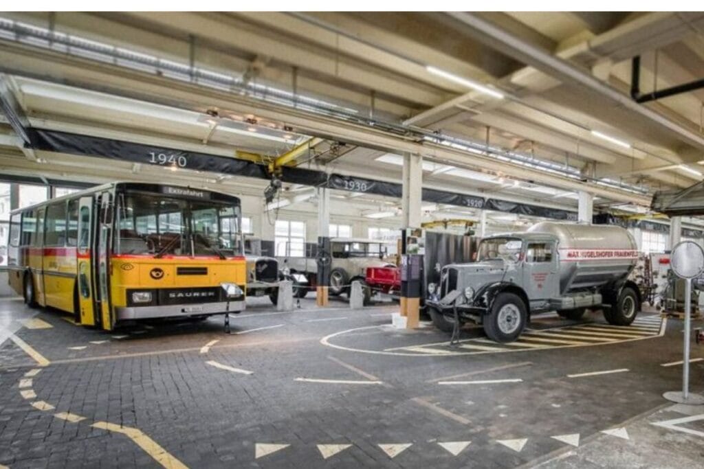 Blick in eine grosse Halle mit einem Postauto und anderen alten Fahrzeugen. – Erprobte Tipps für die Ostschweiz mit Kindern bei Regen.