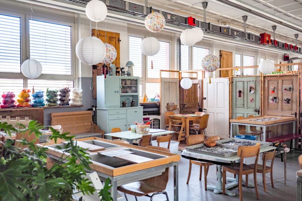 Lichtdurchflutete Halle mit verschiedenen Arbeitsbereichen und viel Material zum Basteln - Ostschweiz mit Kindern bei Regen - unsere Tipps.