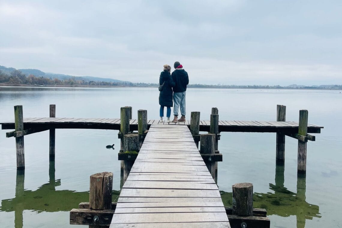 Eine Mutter und ihr Sohn stehen auf einem Steg über einem See, im Hintergrund der graue Himmel. Wenn eine Diagnose endlich Klarheit bringt.