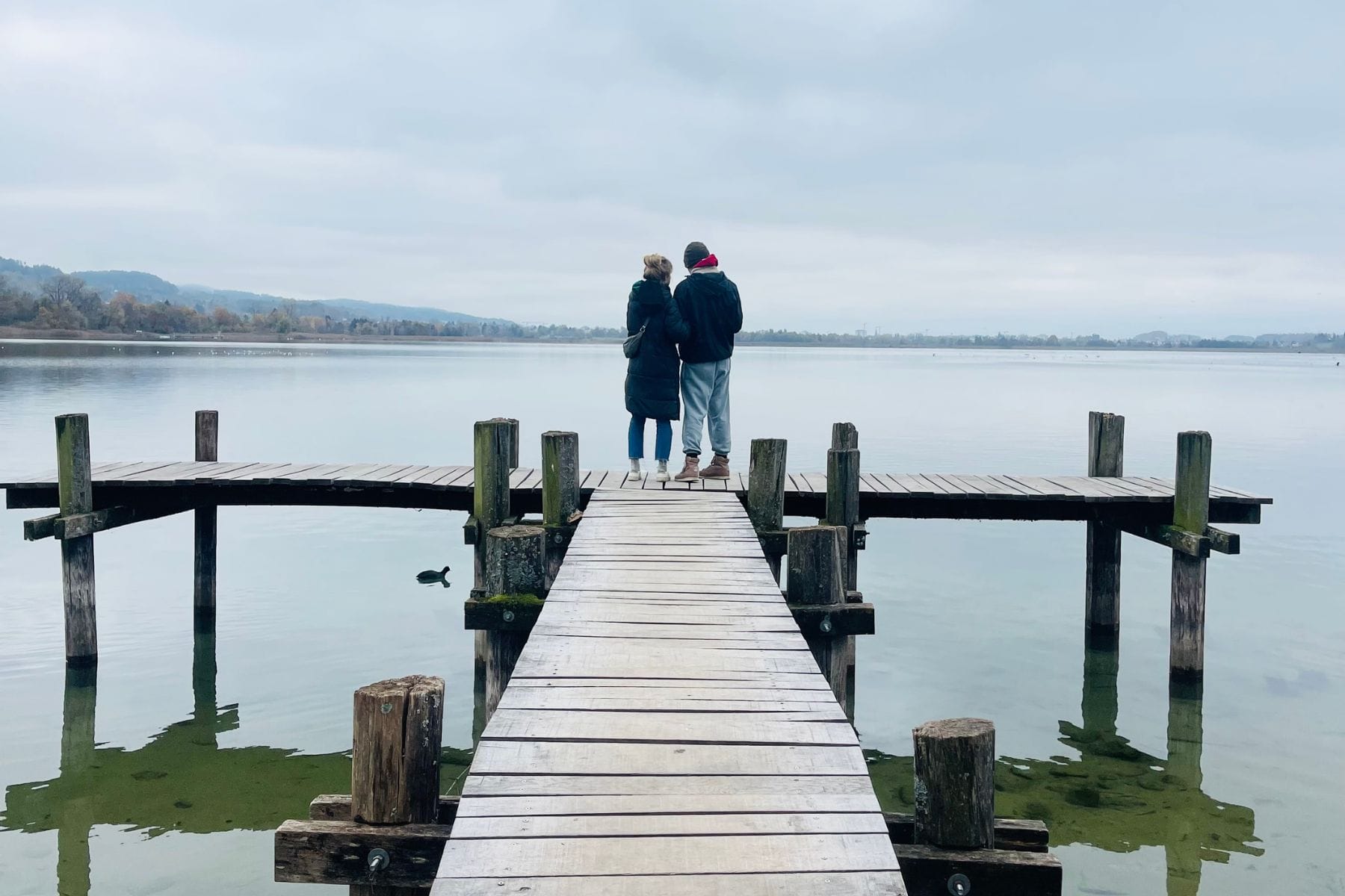 Eine Mutter und ihr Sohn stehen auf einem Steg über einem See, im Hintergrund der graue Himmel. Wenn eine Diagnose endlich Klarheit bringt.