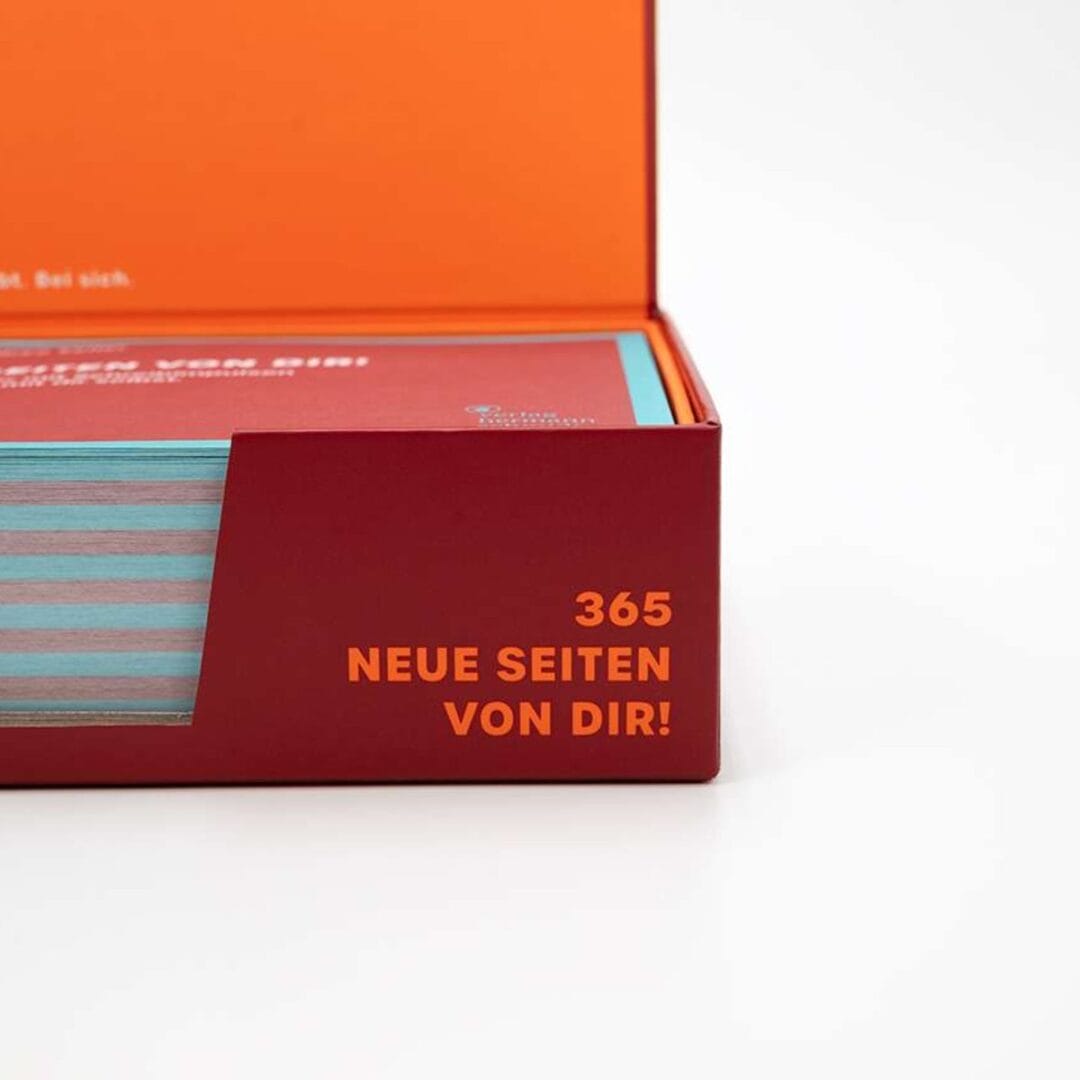 Rote Box des Journaling-Kalenders mit Sichtfenster auf die Blätter und offenem Deckel